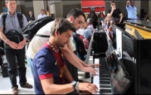 Dos extraños improvisando sobre un piano en la estación de trenes de Paris